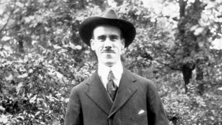 Black & white photo of Edwin Booz smiling in a suit and hat