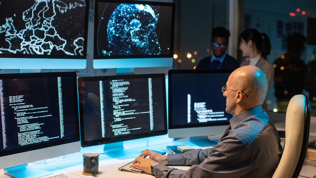 woman reviewing code on a computer monitor